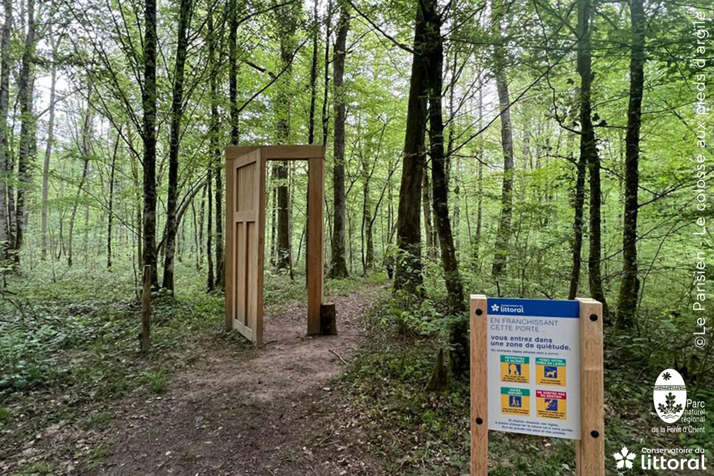 Devant la porte dans al for&ecirc;t, un panneau daonne la consigne : en franchissant cette porte, ...